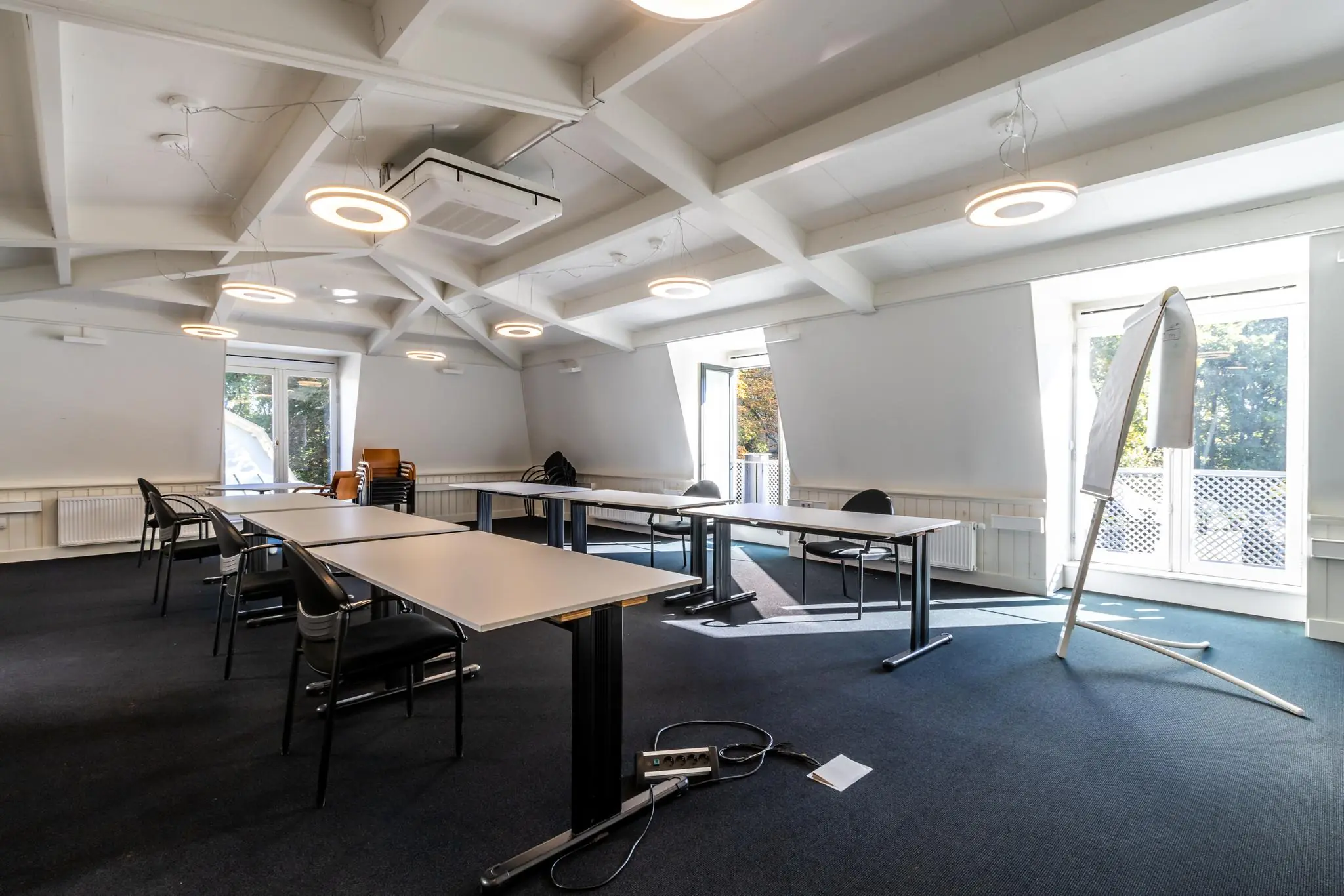 Vergaderruimte aan de Langbroekerdijk A met moderne inrichting, tafels in U-opstelling en veel daglicht via grote ramen.